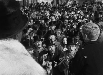 Movie still from “Miracle in Milan” (1951), directed by Vittorio De Sica – A group of people wearing top hats in a crowd; Medium shot, Over the shoulder angle