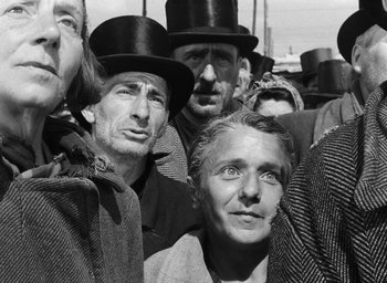 Movie still from “Miracle in Milan” (1951), directed by Vittorio De Sica – A group of people wearing top hats in a crowd; Close Up shot, Low angle