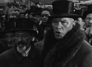 Movie still from “Miracle in Milan” (1951), directed by Vittorio De Sica – Black and white photograph of men in top hats; Medium shot, Low angle