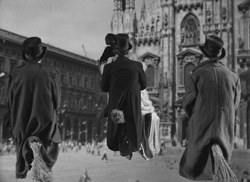 Movie still from “Miracle in Milan” (1951), directed by Vittorio De Sica – A black and white photo of people walking on a street; Wide shot, Low angle