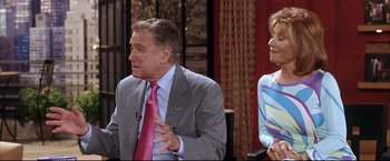 Movie still from “Miss Congeniality 2: Armed & Fabulous” (2005), directed by John Pasquin – A man in a gray suit and a woman in a pink tie; Medium shot, Over the shoulder angle