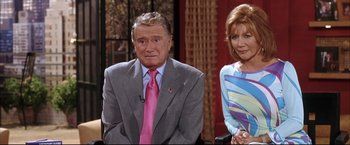 Movie still from “Miss Congeniality 2: Armed & Fabulous” (2005), directed by John Pasquin – A man in a suit and tie next to a woman in a dress; Medium shot, High angle