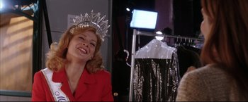 Movie still from “Miss Congeniality 2: Armed & Fabulous” (2005), directed by John Pasquin – A woman wearing a tiara and a red jacket; Medium shot, Low angle