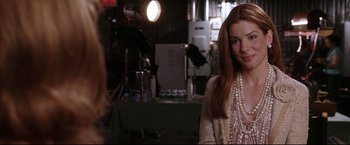 Movie still from “Miss Congeniality 2: Armed & Fabulous” (2005), directed by John Pasquin – A woman with long red hair standing next to a camera; Close Up shot, Over the shoulder angle