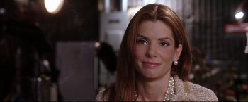 Movie still from “Miss Congeniality 2: Armed & Fabulous” (2005), directed by John Pasquin – A person wearing a necklace; Close Up shot, Over the shoulder angle