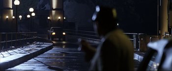 Movie still from “Miss Congeniality 2: Armed & Fabulous” (2005), directed by John Pasquin – A man standing in the middle of the street at night; Wide shot, Over the shoulder angle