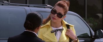 Movie still from “Miss Congeniality 2: Armed & Fabulous” (2005), directed by John Pasquin – A woman in a yellow jacket talking to a man in a black suit; Close Up shot, Over the shoulder angle