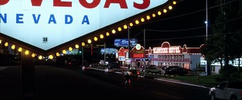Movie still from “Miss Congeniality 2: Armed & Fabulous” (2005), directed by John Pasquin – Cars are parked on the side of the road at night; Extreme Wide shot, High angle