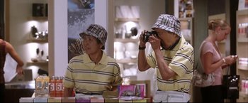 Movie still from “Miss Congeniality 2: Armed & Fabulous” (2005), directed by John Pasquin – Two men are taking a picture of each other; Medium shot, High angle