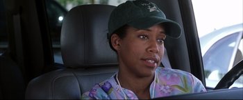 Movie still from “Miss Congeniality 2: Armed & Fabulous” (2005), directed by John Pasquin – A woman sitting in the back of a car wearing a hat; Close Up shot, Over the shoulder angle