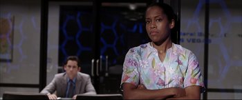 Movie still from “Miss Congeniality 2: Armed & Fabulous” (2005), directed by John Pasquin – A woman in a floral shirt and a man in a gray suit; Medium shot, Over the shoulder angle