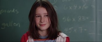 Movie still from “Miss Congeniality 2: Armed & Fabulous” (2005), directed by John Pasquin – A young girl is posing in front of a chalkboard; Close Up shot, Over the shoulder angle