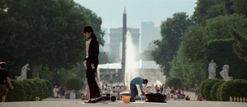 Movie still from “Mister Lonely” (2007), directed by Harmony Korine – A man in a black suit and a black hat is standing on the ground; Extreme Wide shot, Low angle