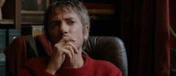 Movie still from “Mister Lonely” (2007), directed by Harmony Korine – A man sitting in a chair with his hand under his chin; Close Up shot, Low angle