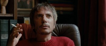 Movie still from “Mister Lonely” (2007), directed by Harmony Korine – A person sitting in a chair; Close Up shot, High angle