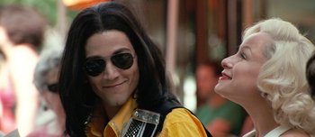Movie still from “Mister Lonely” (2007), directed by Harmony Korine – A man and a woman wearing sun glasses and smiling; Close Up shot, Low angle