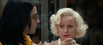 Movie still from “Mister Lonely” (2007), directed by Harmony Korine – A woman smoking a cigarette next to another woman; Close Up shot, Over the shoulder angle