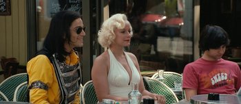 Movie still from “Mister Lonely” (2007), directed by Harmony Korine – Two women sitting at an outdoor table with a glass of wine; Medium shot, Over the shoulder angle