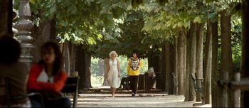 Movie still from “Mister Lonely” (2007), directed by Harmony Korine – A man and a woman are walking in a park; Wide shot, Low angle