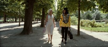 Movie still from “Mister Lonely” (2007), directed by Harmony Korine – A man and a woman walking down a tree lined path; Wide shot, Low angle