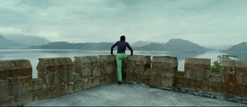 Movie still from “Mister Lonely” (2007), directed by Harmony Korine – A man leaning on a wall looking out at the ocean; Wide shot, Low angle