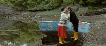 Movie still from “Mister Lonely” (2007), directed by Harmony Korine – A man and a woman standing next to a boat; Wide shot, High angle