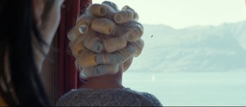Movie still from “Mister Lonely” (2007), directed by Harmony Korine – A woman with blonde hair is sitting in front of a window; Close Up shot, Over the shoulder angle