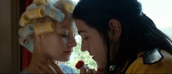 Movie still from “Mister Lonely” (2007), directed by Harmony Korine – Two women with hair curlers eating a strawberry; Close Up shot, Low angle