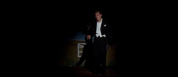 Movie still from “Mister Lonely” (2007), directed by Harmony Korine – A man in a tuxedo is walking on stage; Wide shot, Low angle