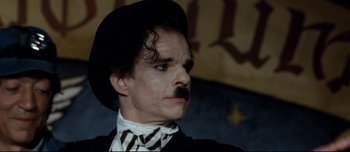 Movie still from “Mister Lonely” (2007), directed by Harmony Korine – A person with a mustache wearing a hat; Close Up shot, Low angle