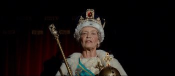 Movie still from “Mister Lonely” (2007), directed by Harmony Korine – An older woman wearing a crown and holding a scepter; Medium shot, Low angle