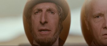 Movie still from “Mister Lonely” (2007), directed by Harmony Korine – A person wearing a hat and beard; Extreme Close Up shot, Overhead angle