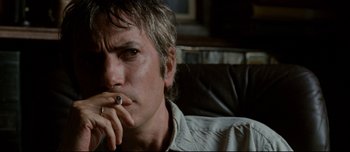 Movie still from “Mister Lonely” (2007), directed by Harmony Korine – A person sitting down with his hand on his chin; Close Up shot, Low angle