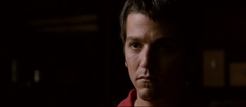 Movie still from “Mister Lonely” (2007), directed by Harmony Korine – A man's face in a dark room; Close Up shot, Low angle