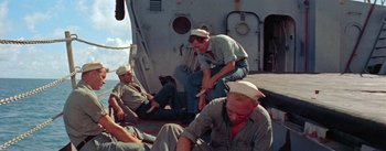 Movie still from “Mister Roberts” (1955), directed by John Ford – A group of men sitting on the deck of a boat; Medium shot, High angle