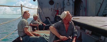 Movie still from “Mister Roberts” (1955), directed by John Ford – Two men sitting on the deck of a boat; Medium shot, High angle