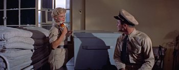 Movie still from “Mister Roberts” (1955), directed by John Ford – A woman in a uniform talking to a man in a uniform; Medium shot, Low angle