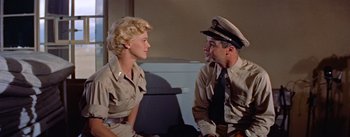 Movie still from “Mister Roberts” (1955), directed by John Ford – A man and a woman sitting next to each other; Medium shot, Low angle