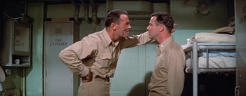 Movie still from “Mister Roberts” (1955), directed by John Ford – A couple of men standing next to each other; Medium shot, High angle