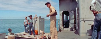 Movie still from “Mister Roberts” (1955), directed by John Ford – A man standing on the deck of a boat; Wide shot, Low angle