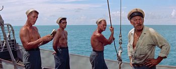 Movie still from “Mister Roberts” (1955), directed by John Ford – Two men standing on a boat in front of the ocean; Medium shot, Low angle
