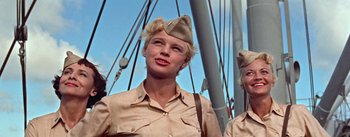 Movie still from “Mister Roberts” (1955), directed by John Ford – A woman in a military uniform standing next to a boat; Close Up shot, Low angle