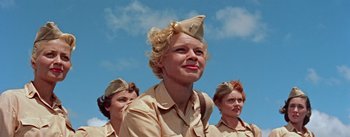Movie still from “Mister Roberts” (1955), directed by John Ford – A group of women dressed in military uniforms; Close Up shot, Low angle