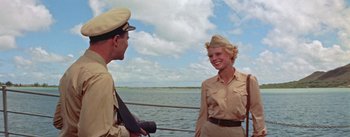 Movie still from “Mister Roberts” (1955), directed by John Ford – A man and a woman in uniform talking on a boat; Medium shot, Low angle
