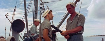 Movie still from “Mister Roberts” (1955), directed by John Ford – A group of men standing next to each other on top of a boat; Medium shot, Low angle