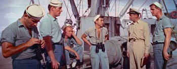 Movie still from “Mister Roberts” (1955), directed by John Ford – A group of men standing next to each other on a boat; Medium shot, High angle