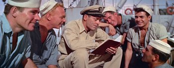 Movie still from “Mister Roberts” (1955), directed by John Ford – A group of men sitting next to each other on a boat; Medium shot, High angle