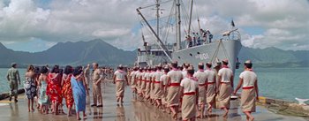 Movie still from “Mister Roberts” (1955), directed by John Ford – A large group of people are standing in front of a boat; Extreme Wide shot, High angle