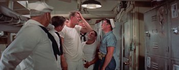Movie still from “Mister Roberts” (1955), directed by John Ford – A group of men standing next to each other on a boat; Medium shot, Low angle
