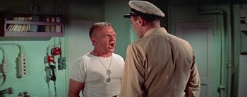 Movie still from “Mister Roberts” (1955), directed by John Ford – Two men in white shirts and a hat one of which is yelling at the other; Medium shot, Low angle